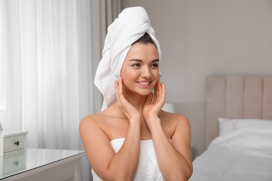 Photo of Beautiful young woman with hair wrapped in towel at home