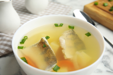 Photo of Delicious fish soup in bowl on table, closeup
