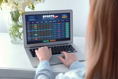 Image of Woman betting on sports using laptop at table, closeup. Bookmaker website on screen