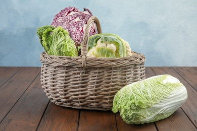 Basket with tasty cabbages on wooden table