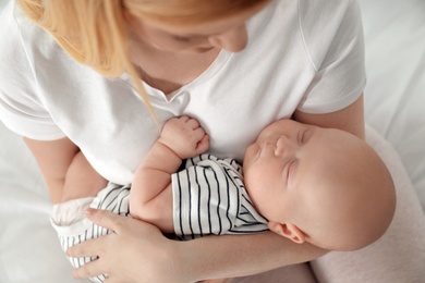 Mother with her baby on bed, above view