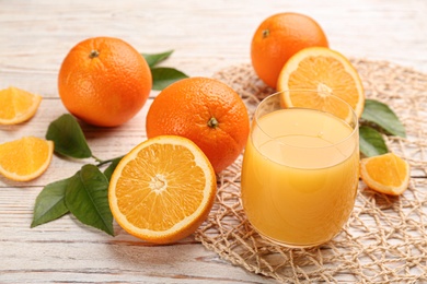 Delicious orange juice and fresh fruits on white wooden table