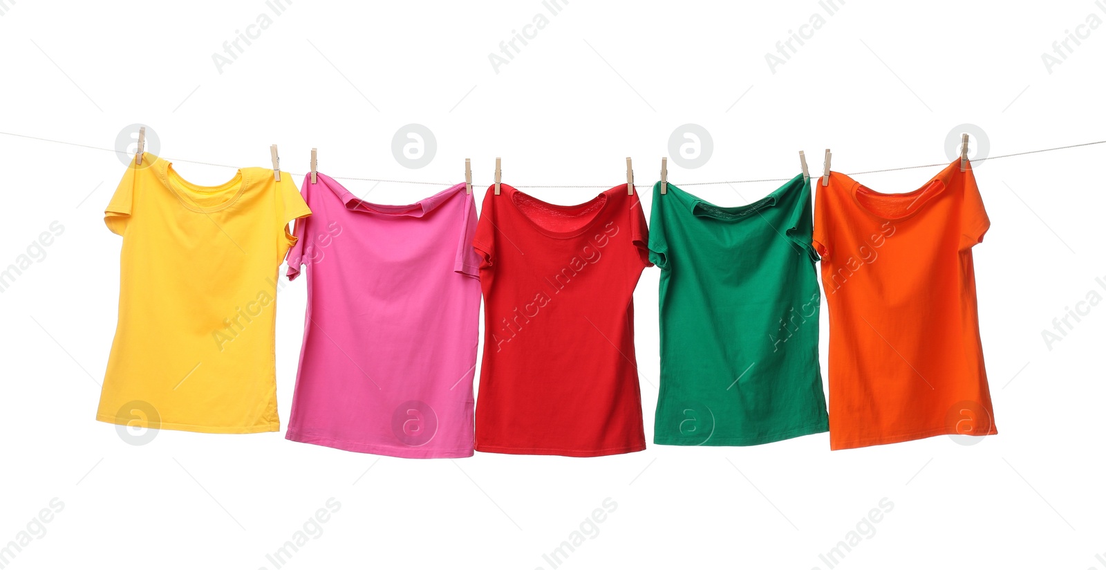 Photo of Different bright t-shirts drying on washing line against white background