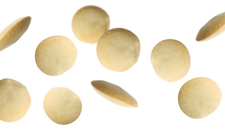 Many lentils falling on white background, banner design. Vegan diet 