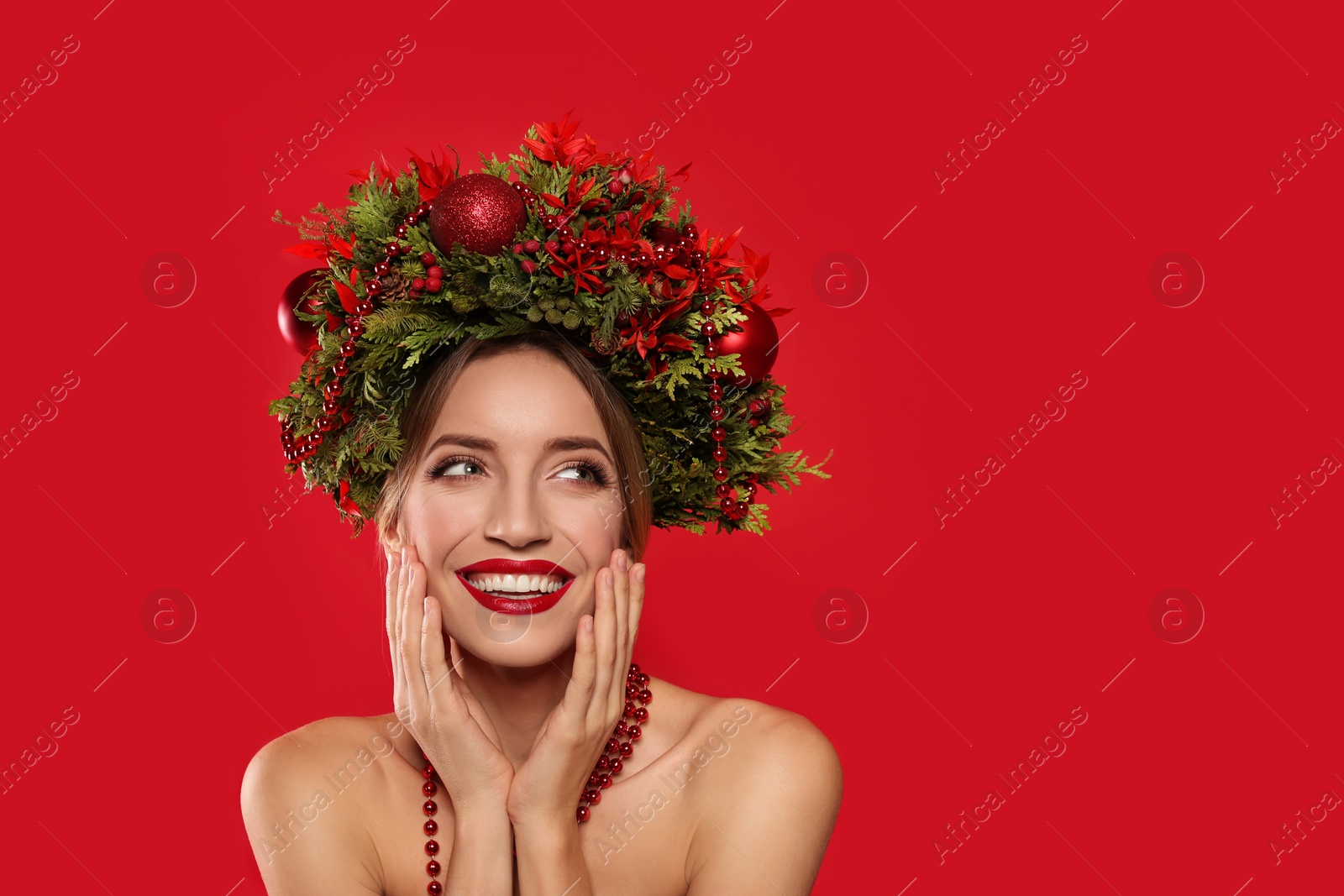 Photo of Beautiful young woman wearing Christmas wreath on red background. Space for text