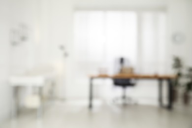 Photo of Blurred view of modern medical office with doctor's workplace. Interior design