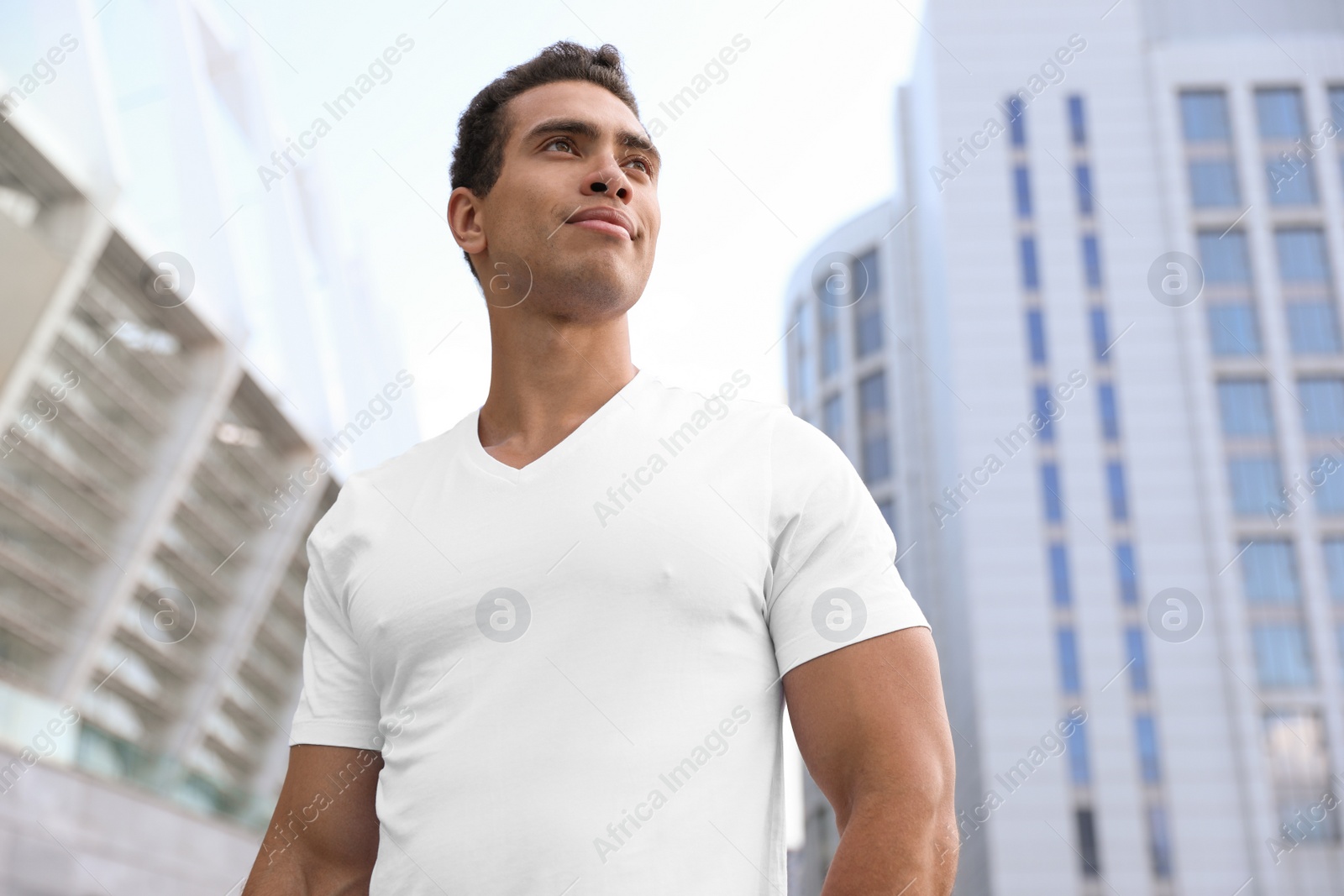 Photo of Handsome young African-American man on city street, low angle view
