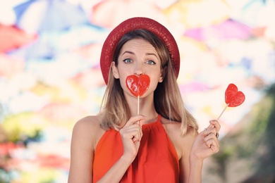 Beautiful woman with candies on city street