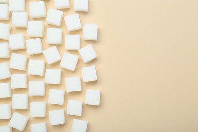 White sugar cubes on beige background, top view. Space for text