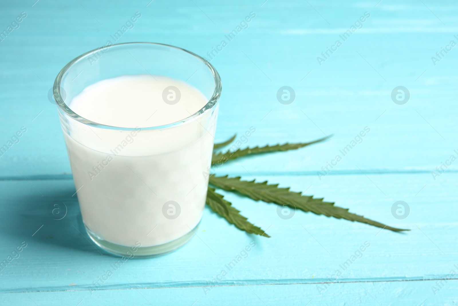 Photo of Glass of hemp milk on wooden background