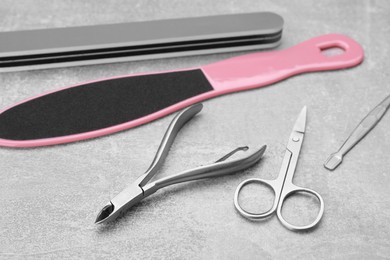 Photo of Set of pedicure tools on light gray background, closeup