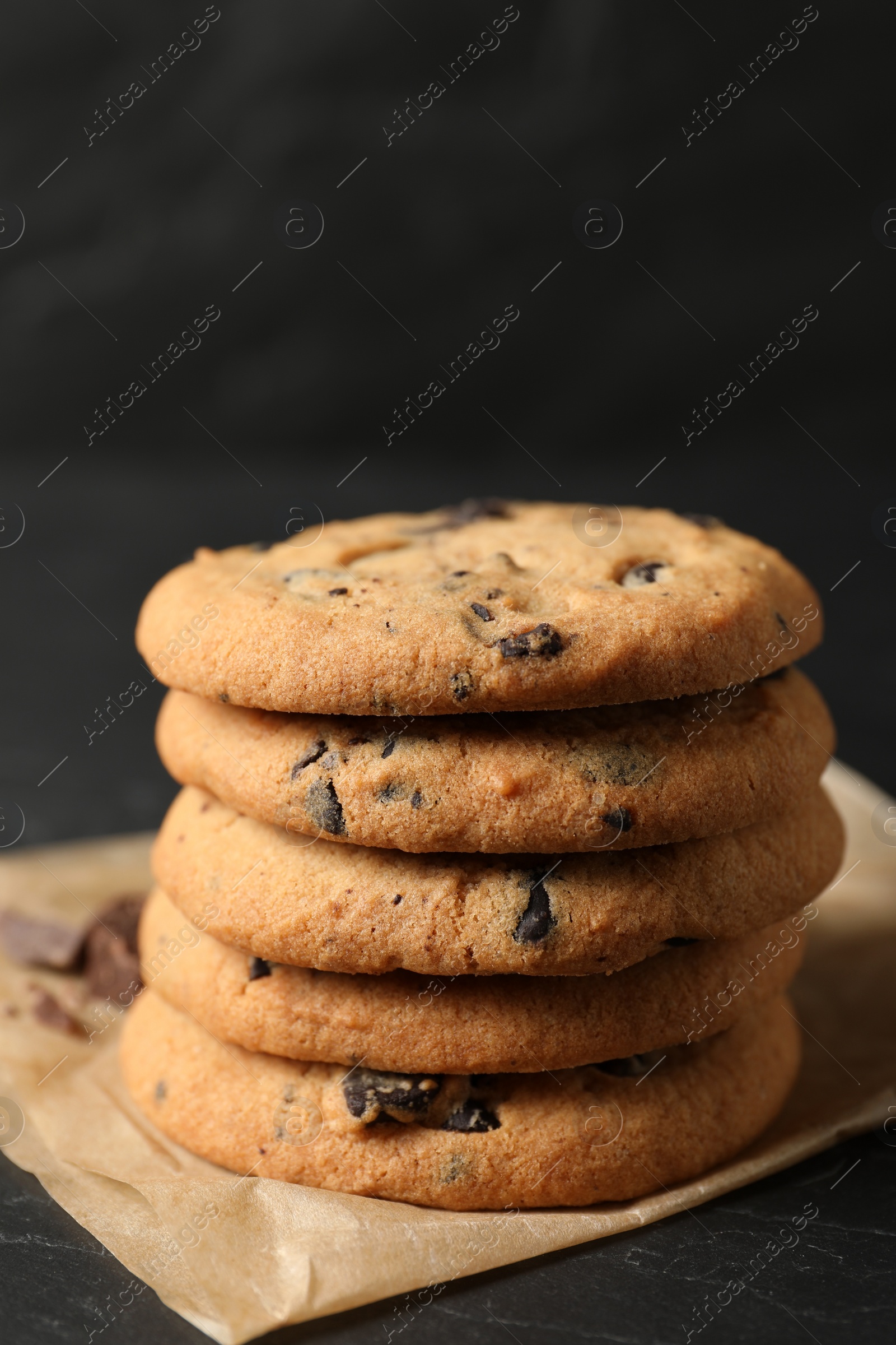 Photo of Delicious chocolate chip cookies on black table