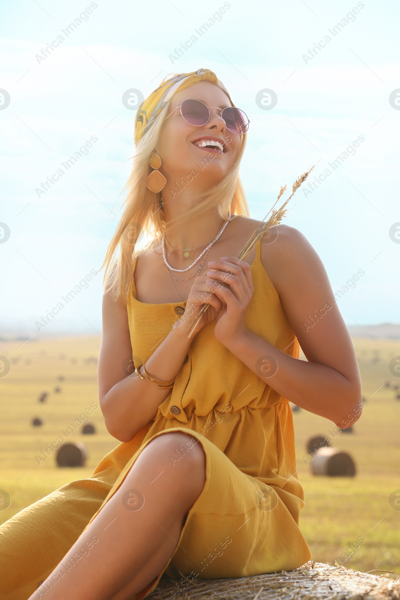 Photo of Beautiful happy hippie woman with spikelets in field