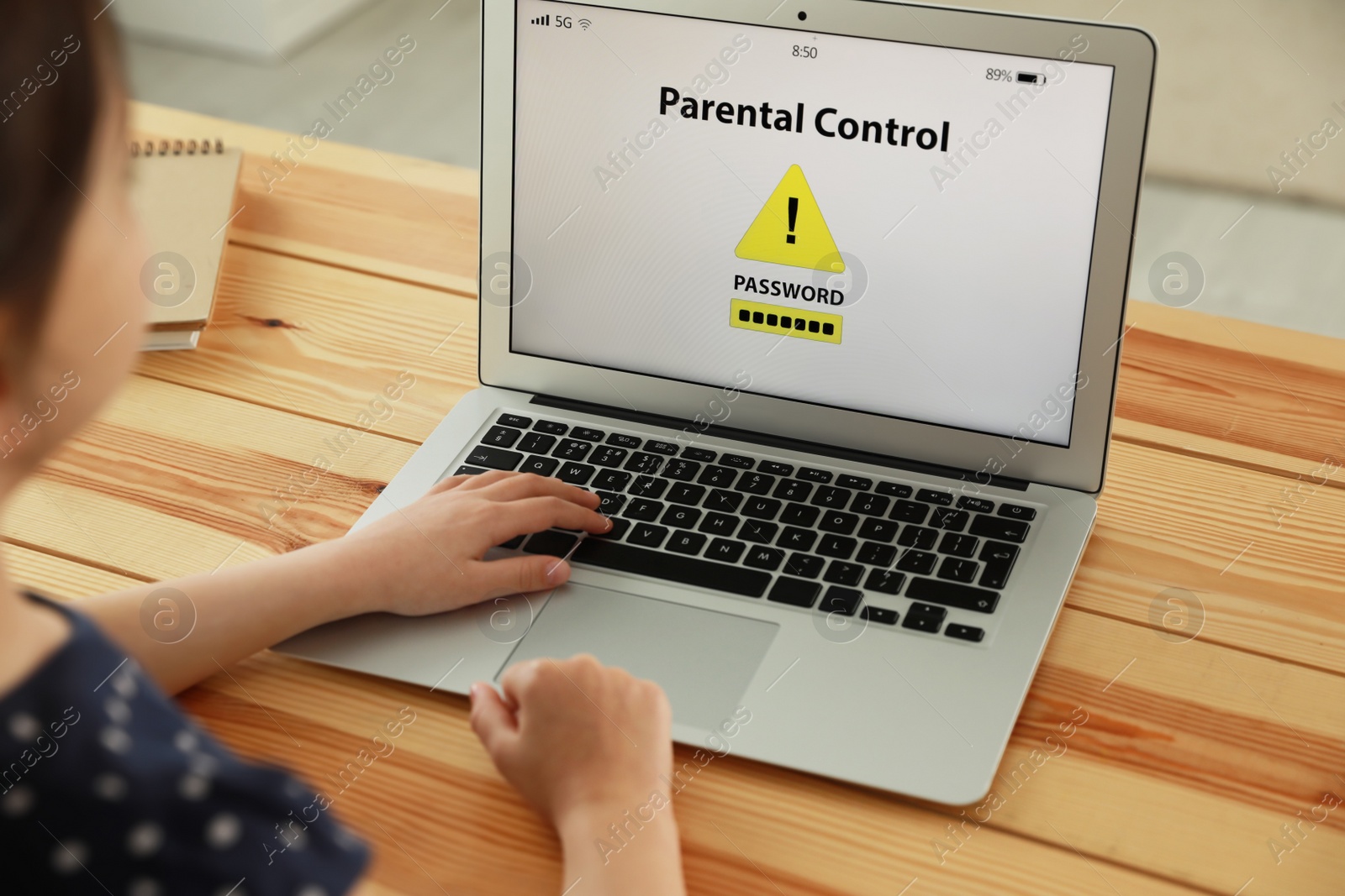 Photo of Child using laptop with installed parental control app at home, closeup. Cyber safety