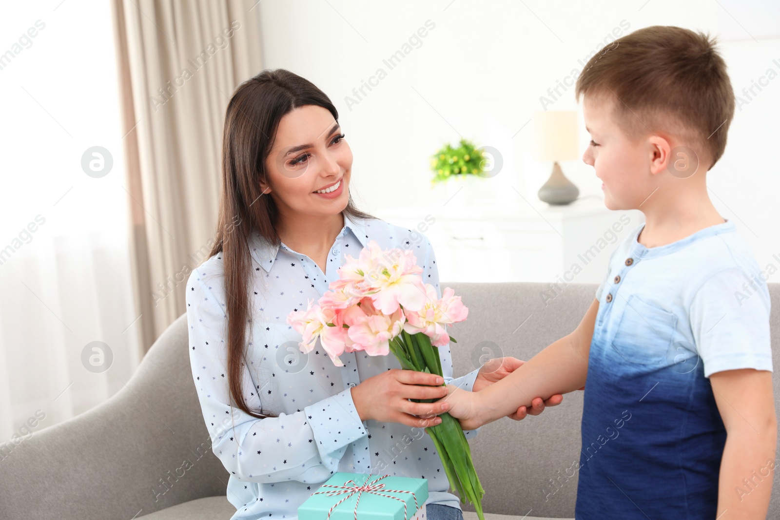 Photo of Little son congratulating his mom at home. Happy Mother's Day