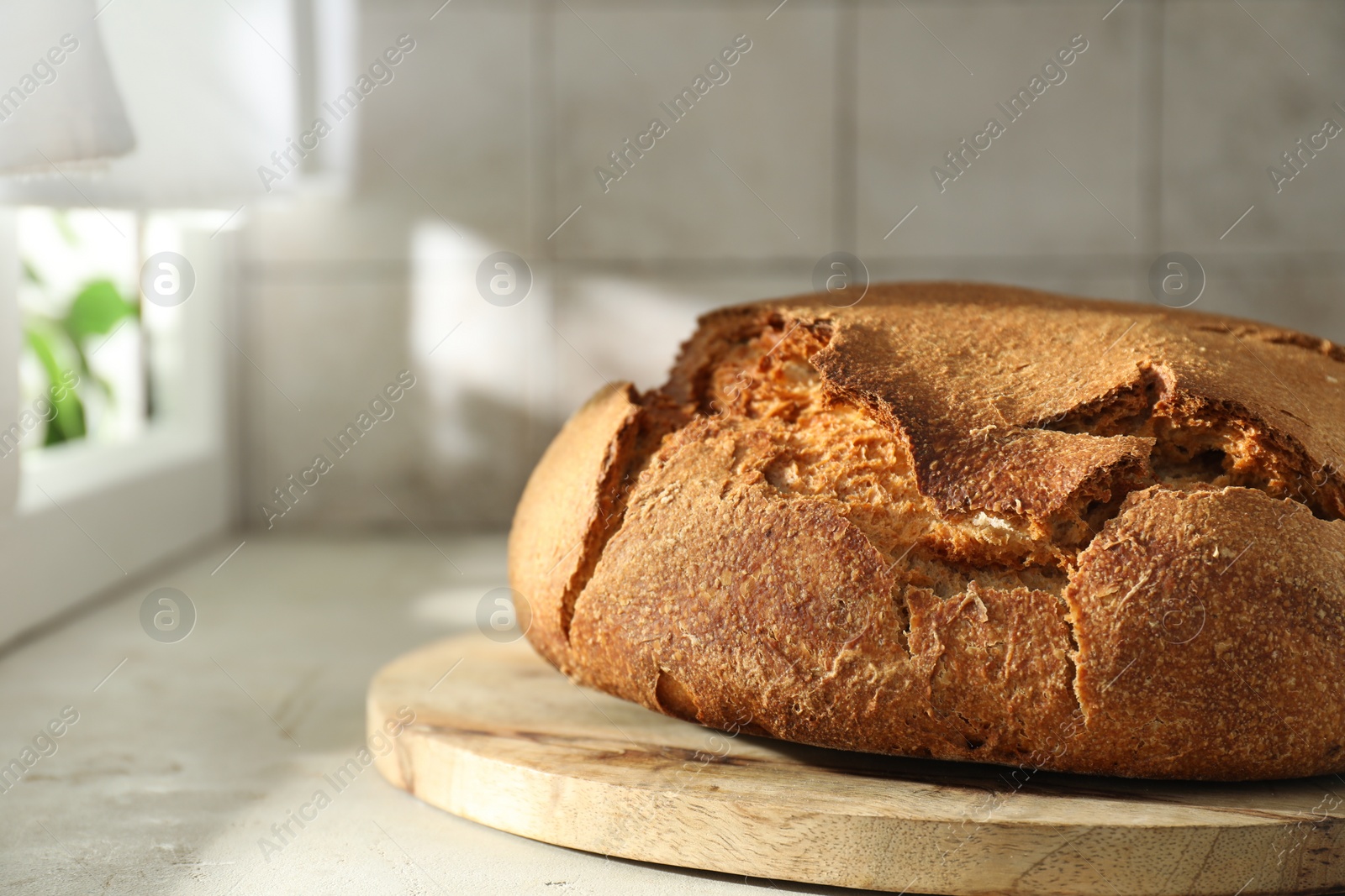 Photo of Freshly baked sourdough bread on light table, closeup. Space for text