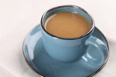 Delicious coffee in cup on white table, closeup