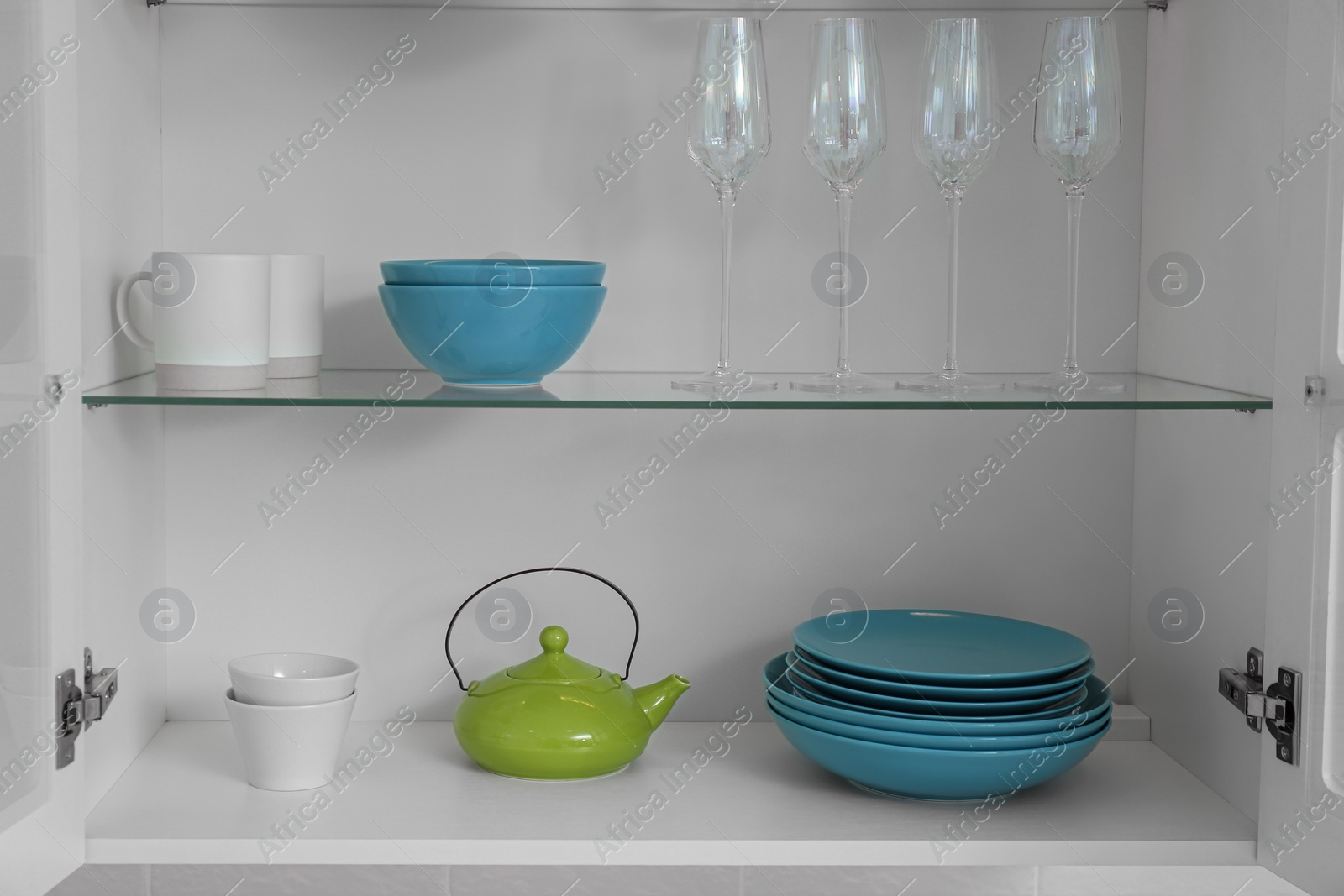 Photo of Open kitchen cabinet with different clean dishware