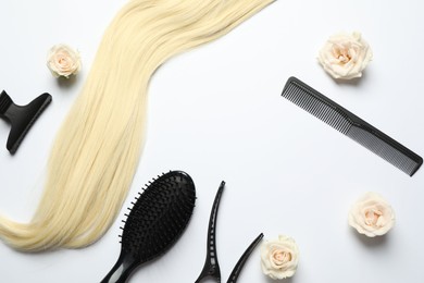 Flat lay composition with different hairdresser tools and flowers on white background, space for text