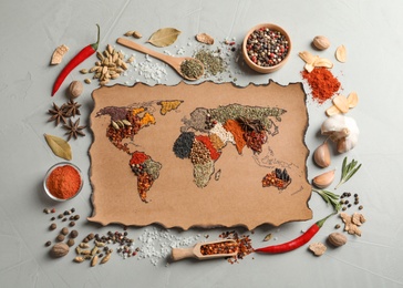 Paper with world map made of different aromatic spices on gray background, flat lay