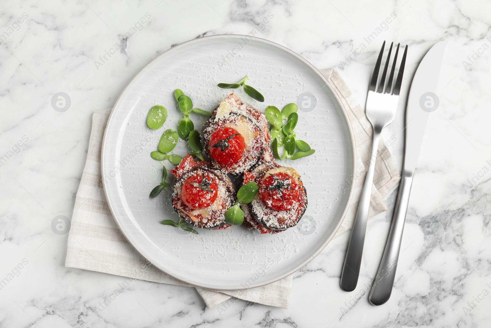 Photo of Baked eggplant with tomatoes, cheese and basil served on white marble table, flat lay