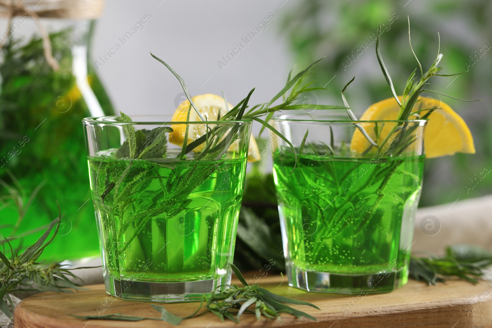 Photo of Refreshing tarragon drink with lemon slices on table, closeup