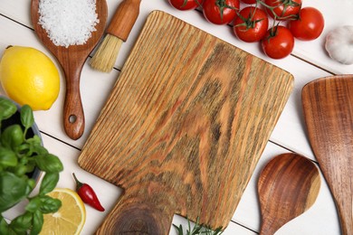 Flat lay composition with cooking utensils and fresh ingredients on white wooden table