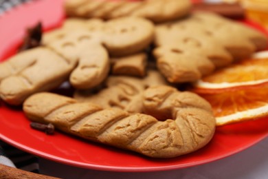 Photo of Different tasty cookies on red plate, closeup