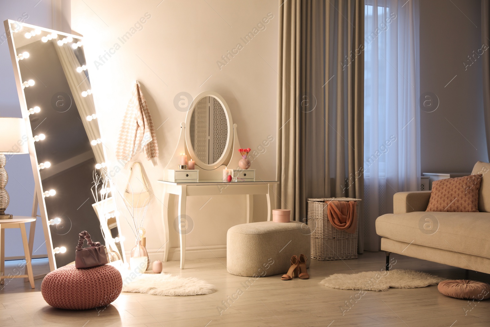 Photo of Large mirror with light bulbs and dressing table in stylish room. Interior design