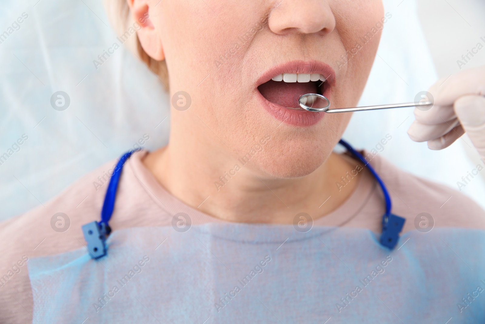 Photo of Dentist examining patient's teeth in modern clinic, closeup