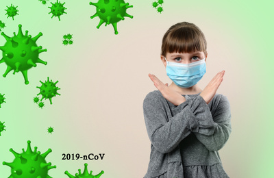 Image of Little girl wearing medical mask on light background. Virus protection