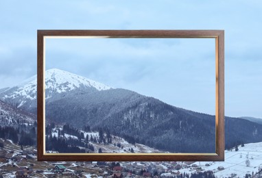 Wooden frame and beautiful mountains covered with snow in winter