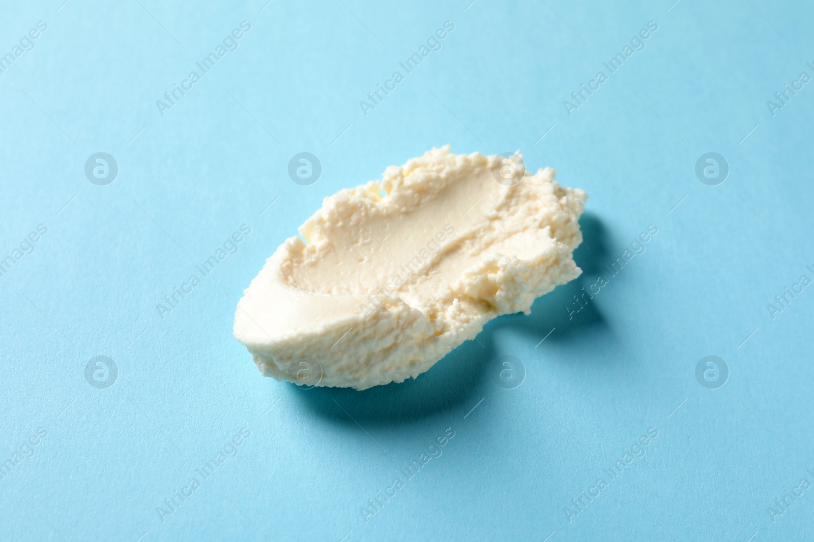 Photo of Smear of tasty cream cheese on color background