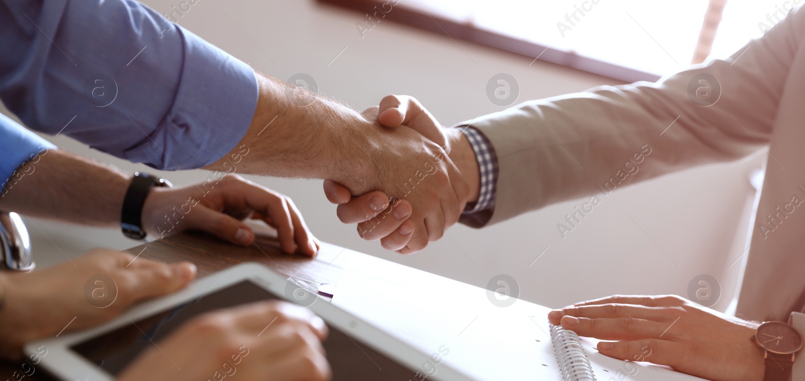 Image of Business partners shaking hands at table after meeting in office, closeup. Banner design