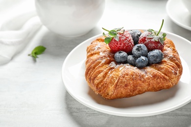 Photo of Fresh delicious puff pastry with sweet berries served on light table. Space for text