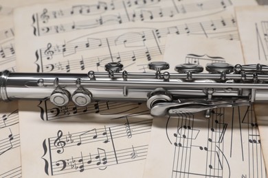 Photo of Classical flute on sheets with musical notes, closeup