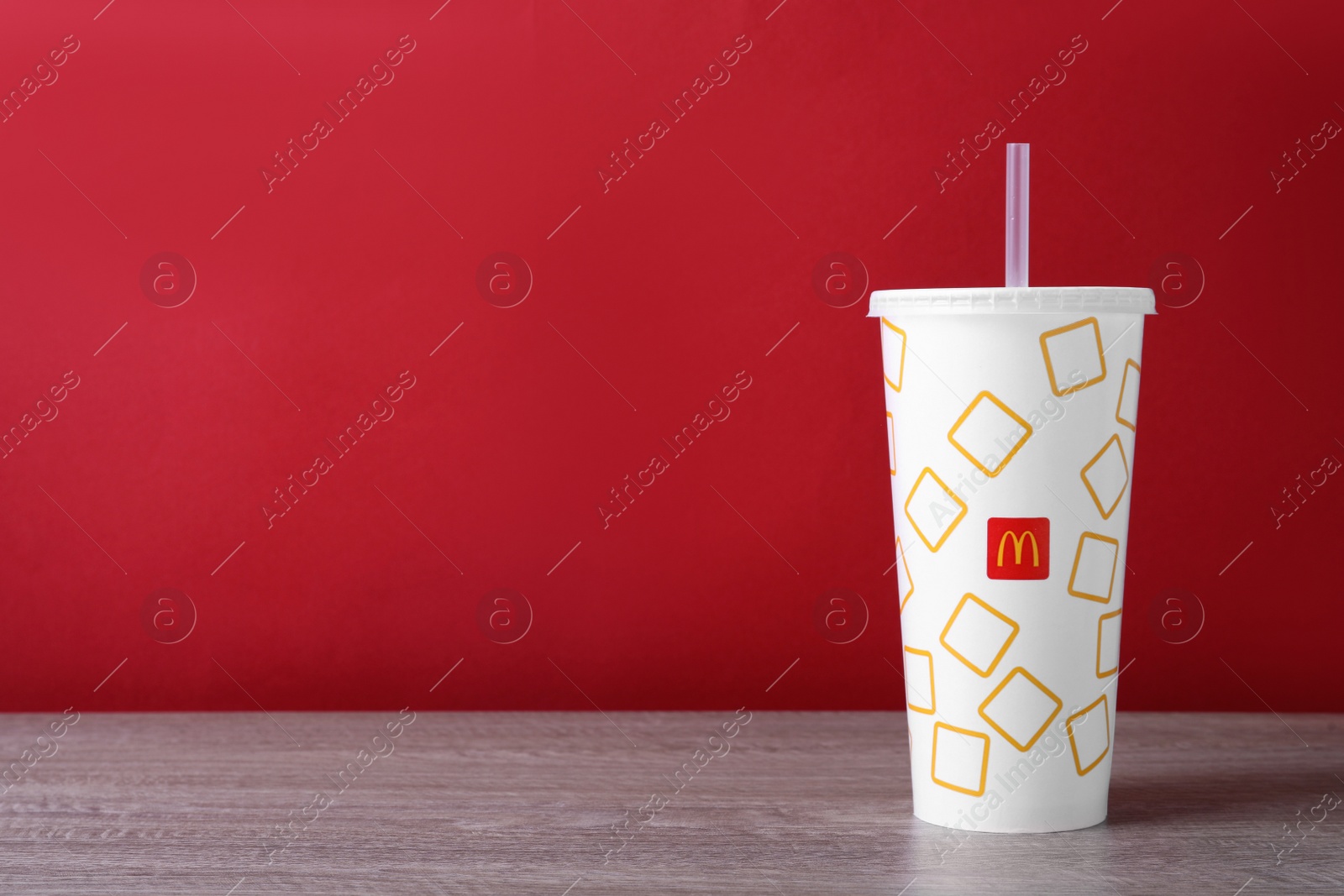 Photo of MYKOLAIV, UKRAINE - AUGUST 12, 2021: Cold McDonald's drink on wooden table. Space for text