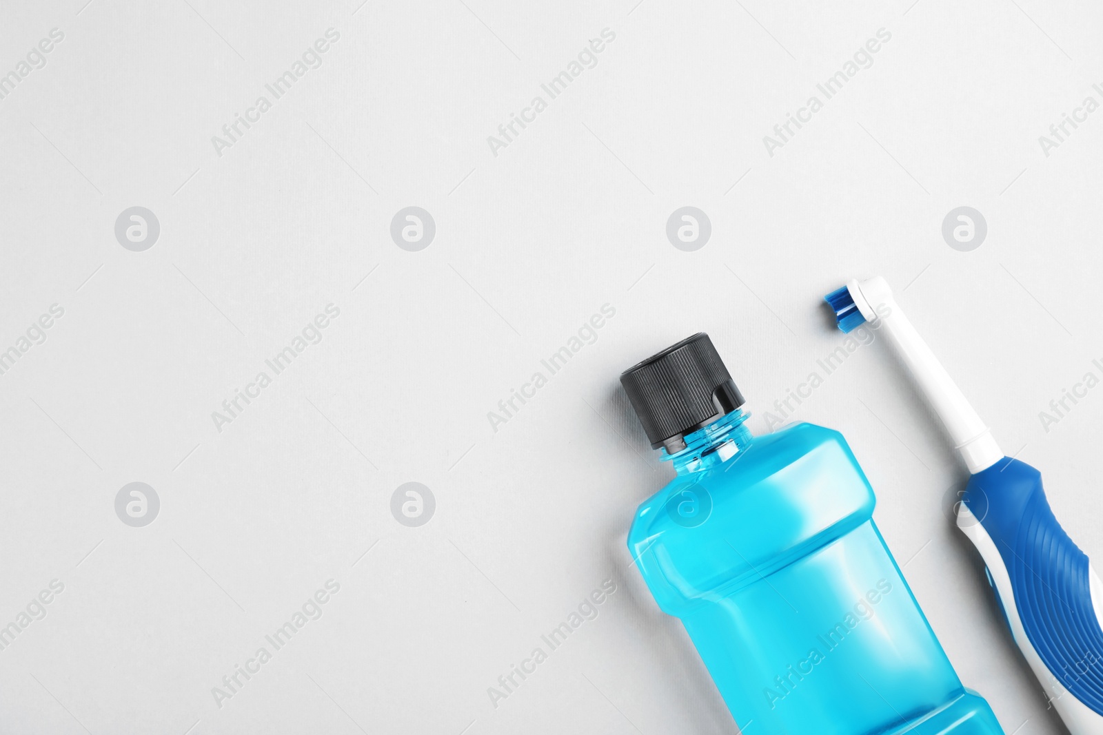 Photo of Flat lay composition with mouthwash, toothbrush and space for text on light background. Teeth hygiene