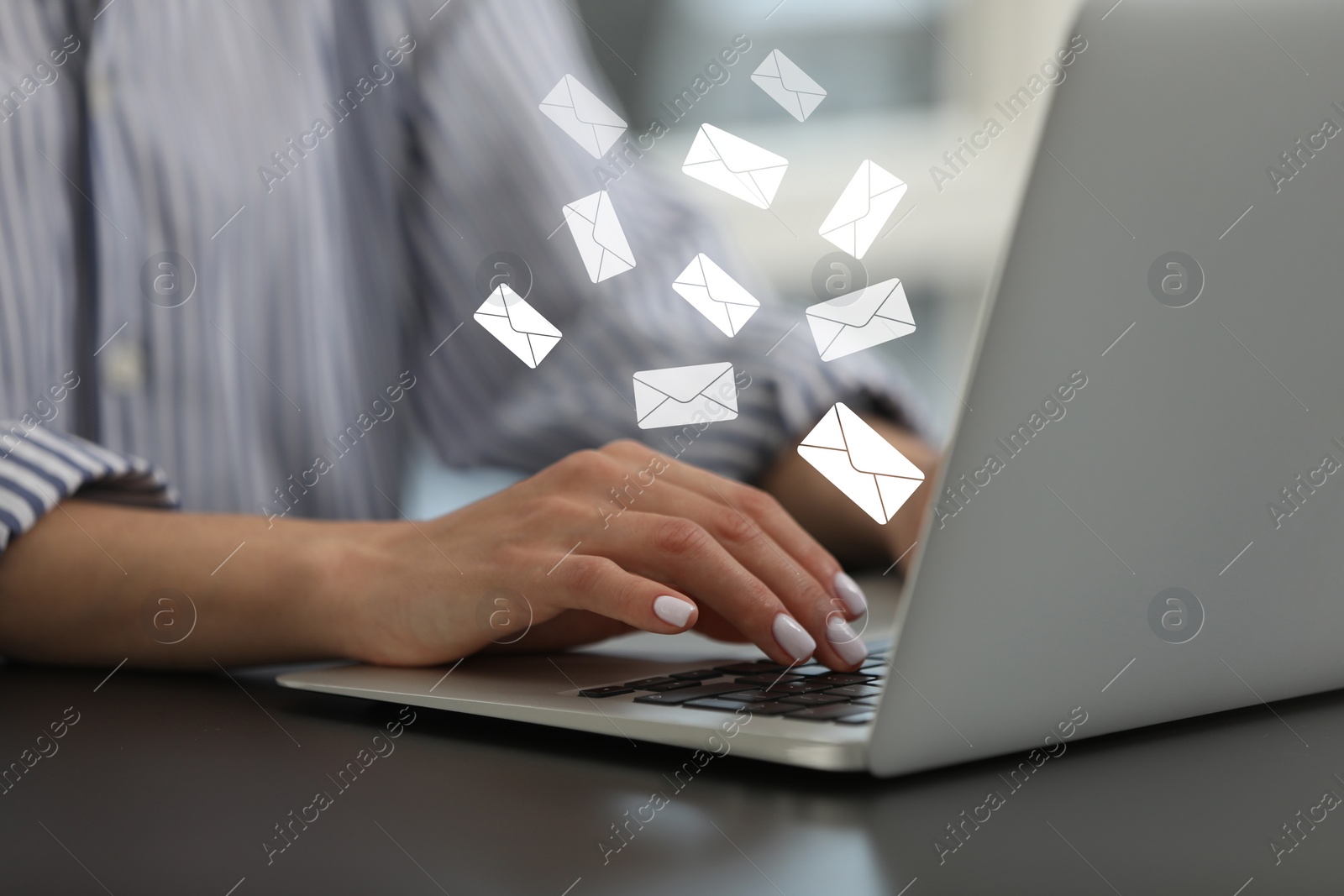 Image of Email. Woman using laptop at table, closeup. Letter illustrations over device