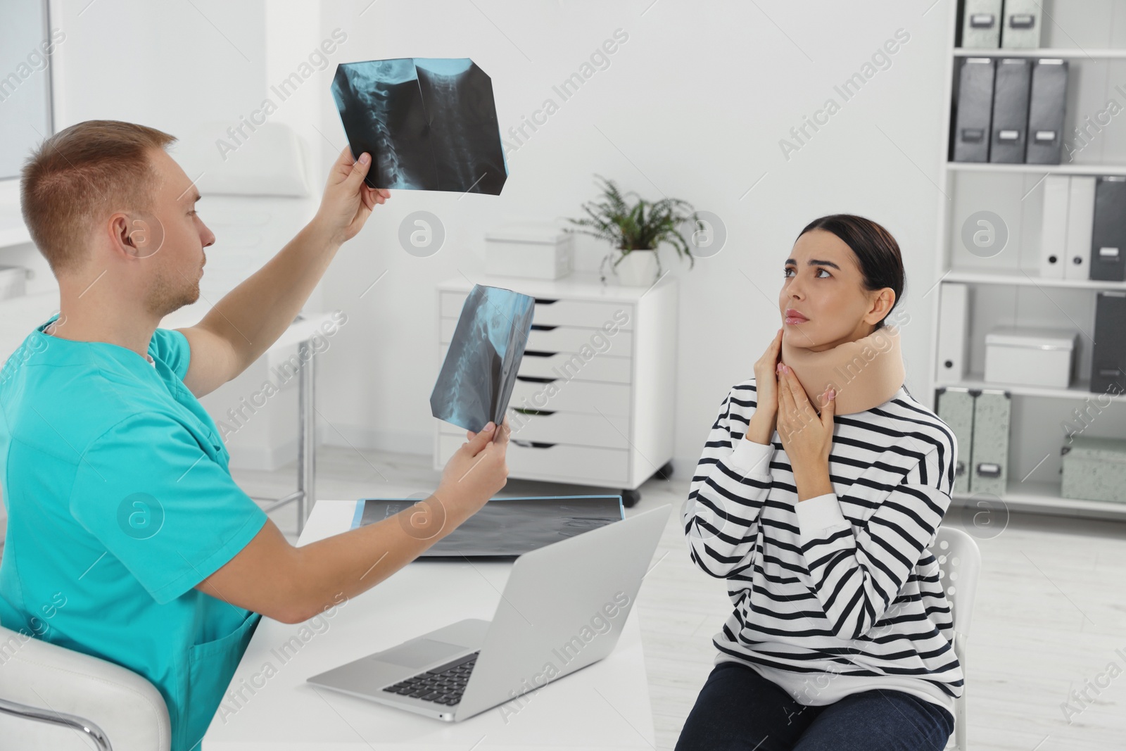 Photo of Doctor with neck MRI images consulting patient in clinic