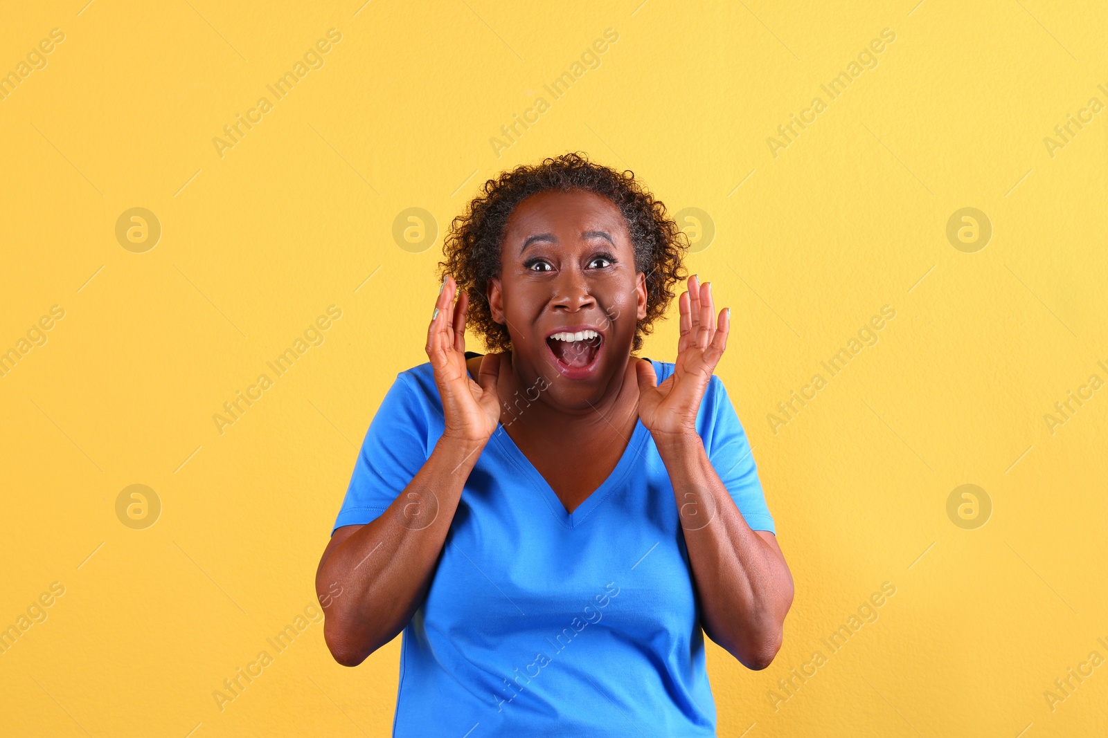 Photo of Portrait of happy African-American woman on yellow background
