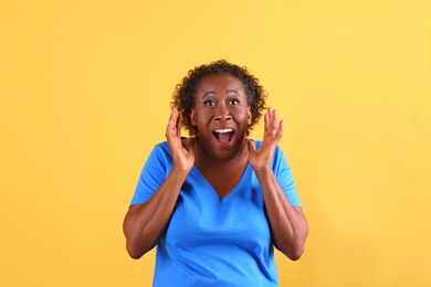Portrait of happy African-American woman on yellow background