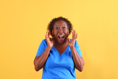 Photo of Portrait of happy African-American woman on yellow background