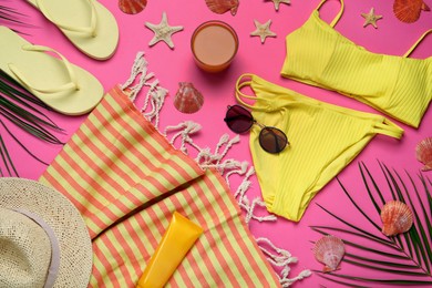 Flat lay composition with different beach objects on pink background