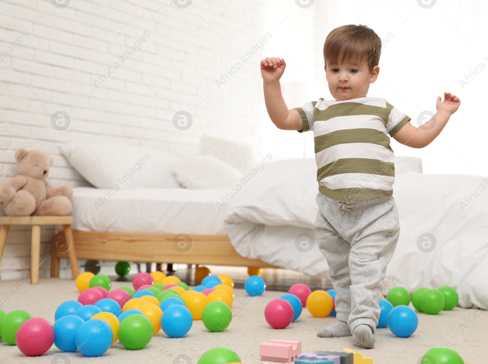 Photo of Cute little children playing with toys on floor at home