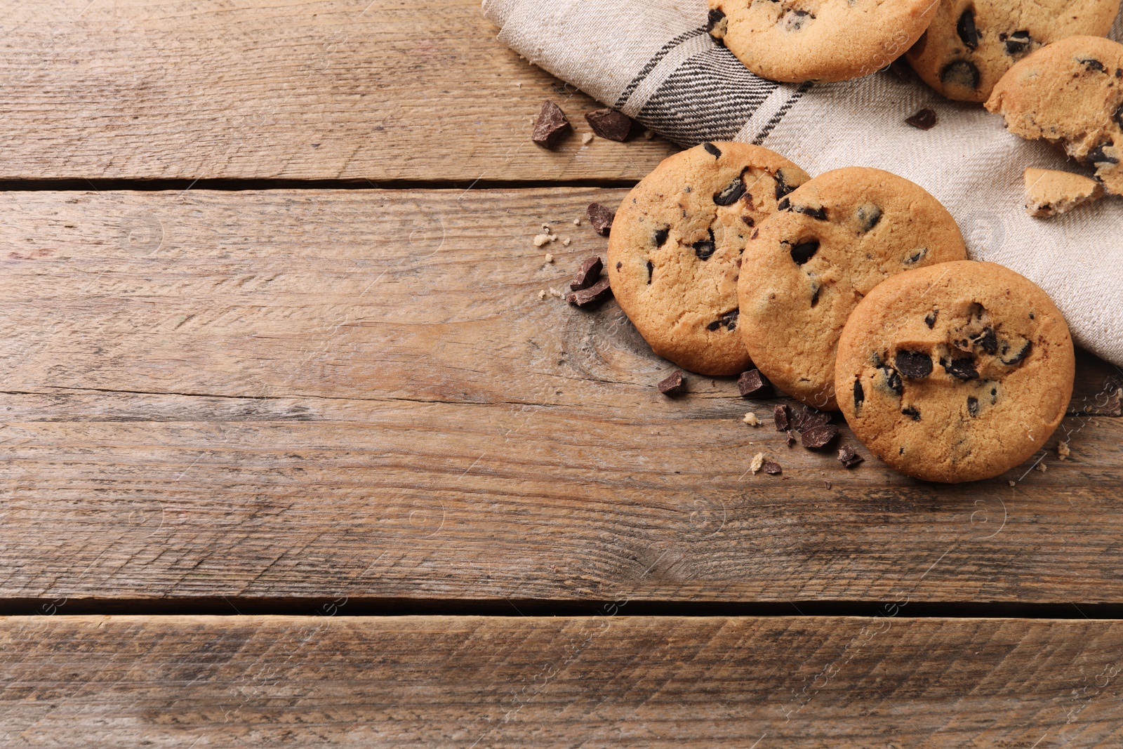 Photo of Delicious chocolate chip cookies on wooden table, flat lay. Space for text