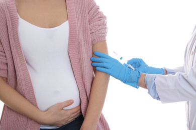 Photo of Doctor giving injection to pregnant woman on white background, closeup. Vaccination concept