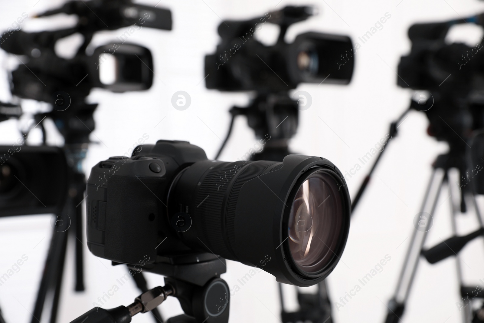 Photo of Modern video camera indoors, focus on lens. Professional media equipment for broadcasting event