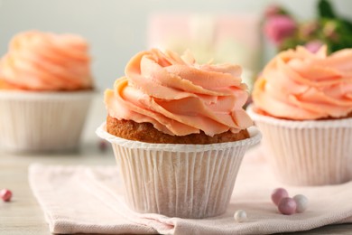 Tasty cupcake with cream on table, closeup view