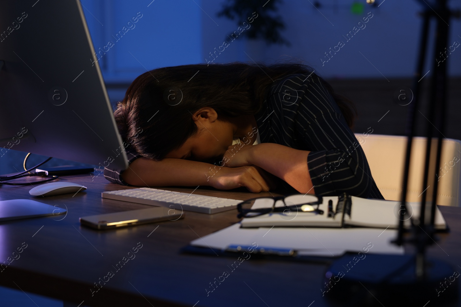 Photo of Tired overworked businesswoman napping at night in office